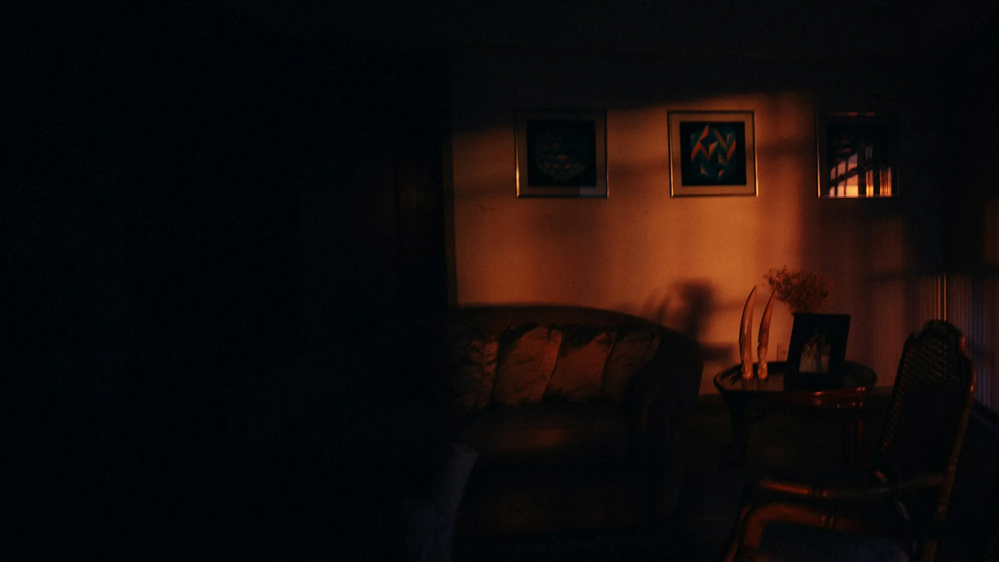 Framed photographs on a living room wall in warm evening light